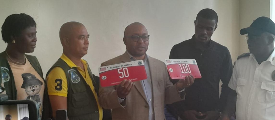 Minister Sirleaf Ralph Tyler proudly displays the newly designed Non-Revenue plates during the launch event at the Ministry of Transport.